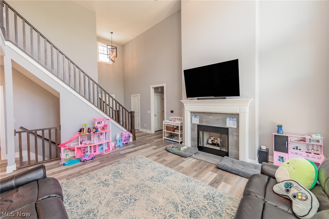 Living room featuring a notable chandelier, a towering ceiling, and wood-type flooring