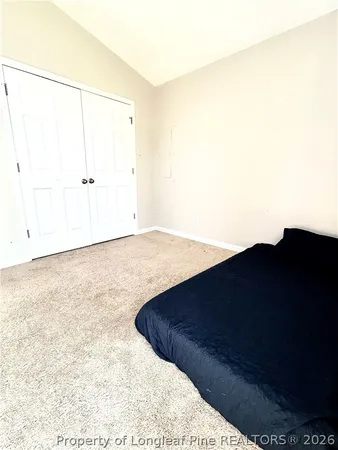 a bedroom with a bed and white cabinets