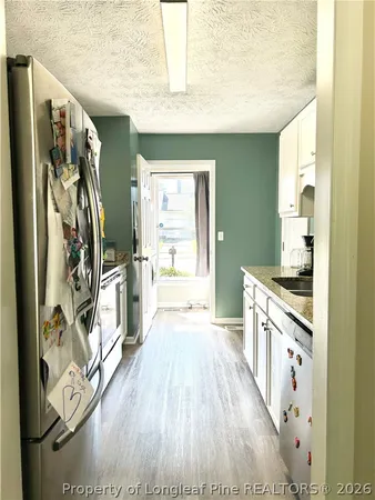 a view of a kitchen with wooden floor and electronic appliances