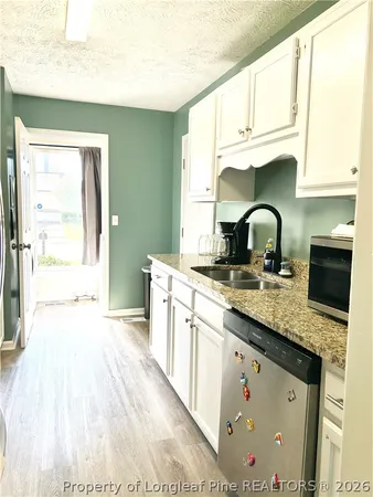 a kitchen with stainless steel appliances granite countertop a sink a stove and a wooden floors