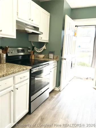 a kitchen with a stove and a white cabinet