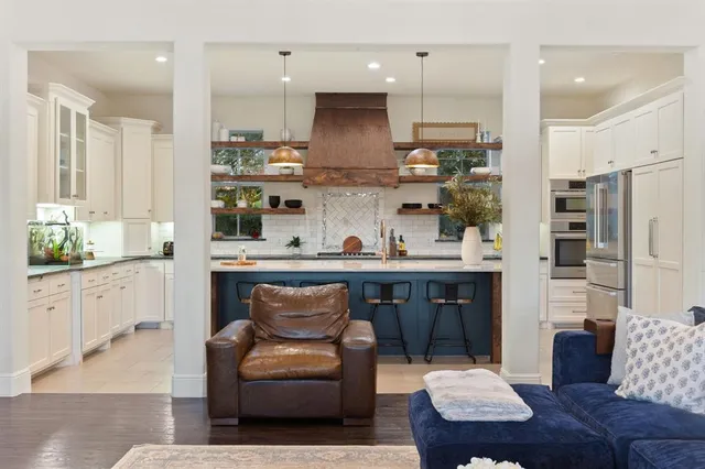 a kitchen with stainless steel appliances granite countertop a refrigerator and a stove top oven