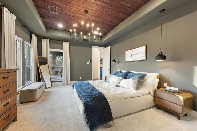 a spacious bedroom with a bed and a chandelier