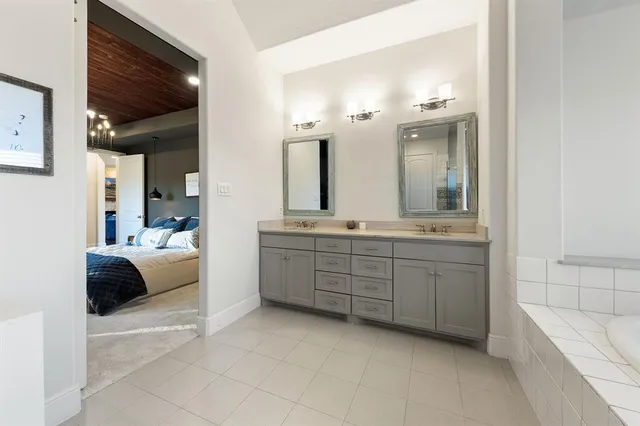a spacious bathroom with a tub sink and mirror