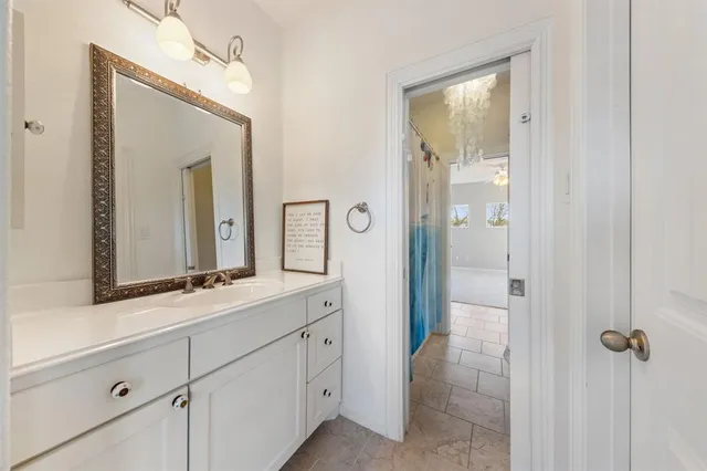 a en suite bathroom with a sink mirror and a shower