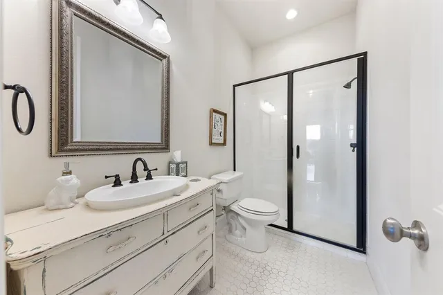 a bathroom with a double vanity sink toilet and mirror