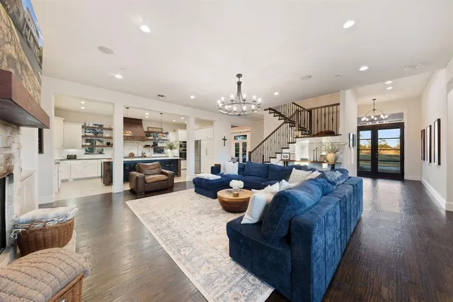 a living room with furniture kitchen view and a wooden floor