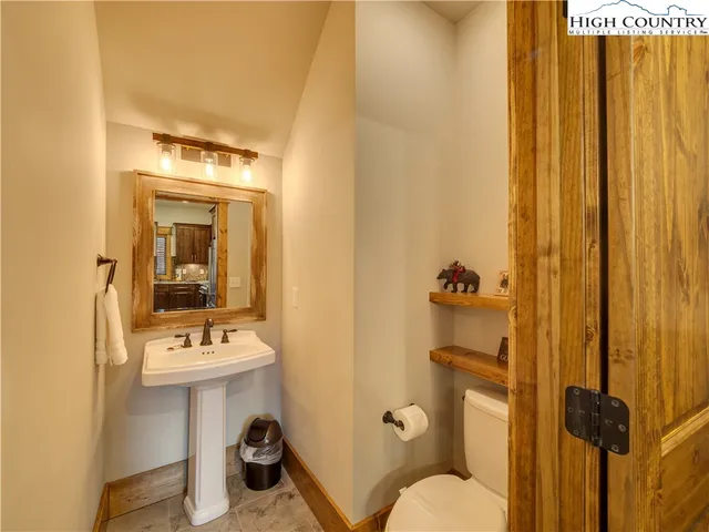 a bathroom with a sink and mirror with toilet