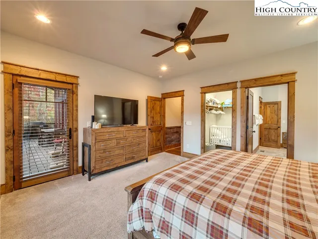 a bedroom with a large bed and a flat tv screen