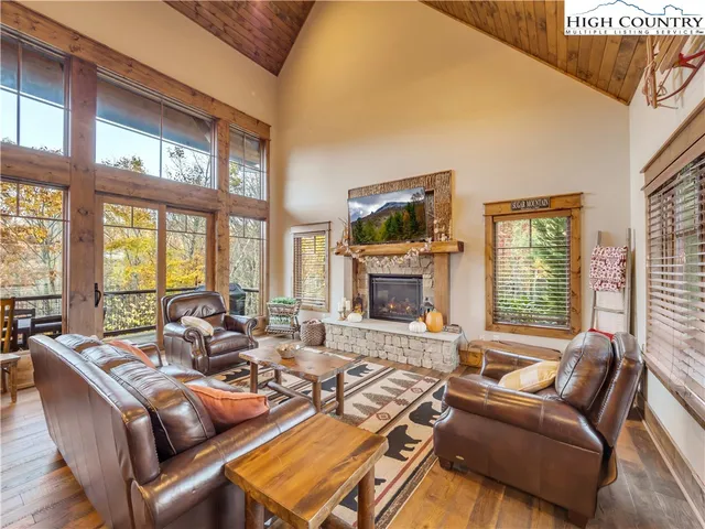 a living room with furniture large window and a fireplace