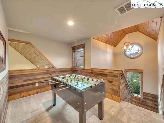 a view of a hallway with a dining table chair and chandelier