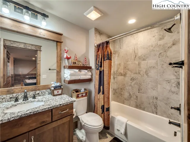 a bathroom with a granite countertop sink toilet tub and shower