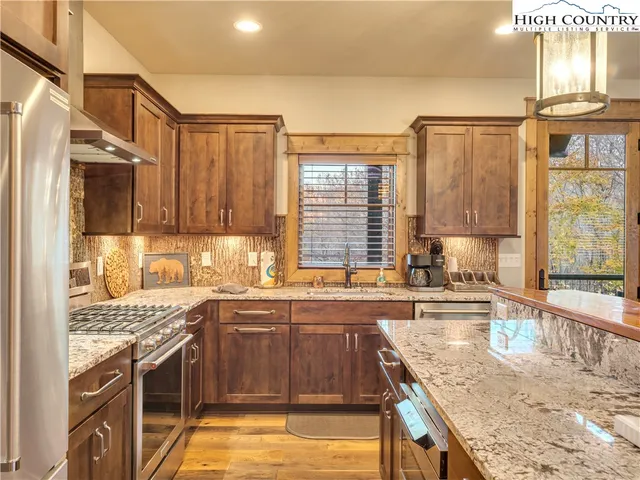 a kitchen with stainless steel appliances granite countertop a sink stove and refrigerator