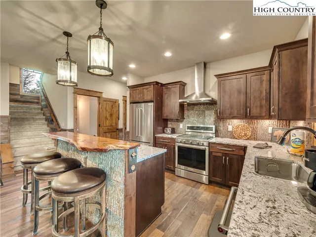 a kitchen with stainless steel appliances granite countertop a stove a sink and a refrigerator