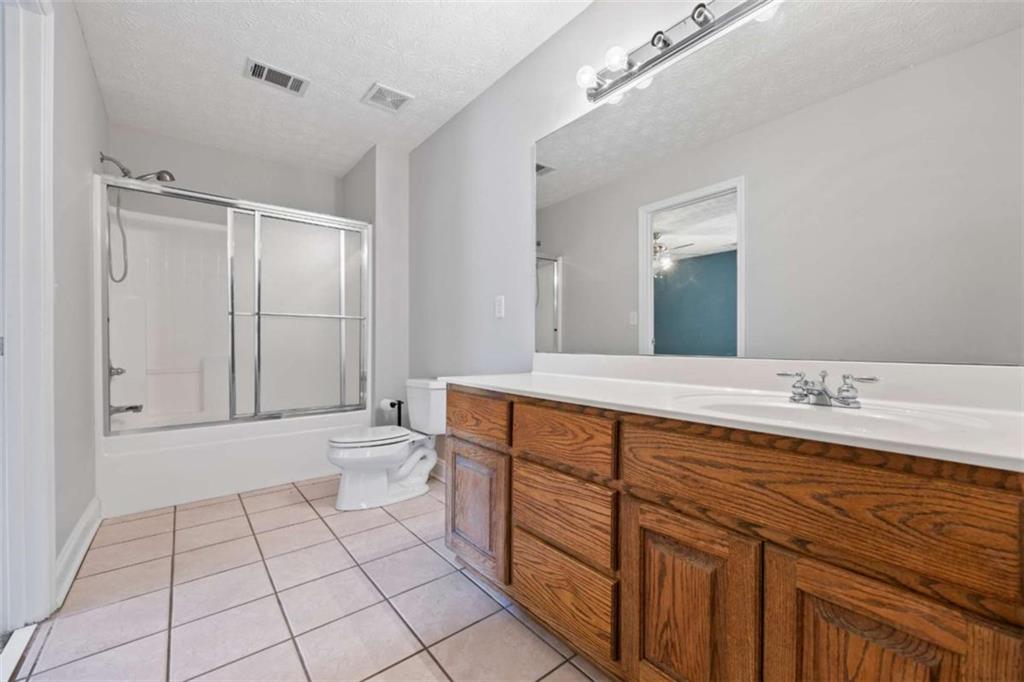 3651 Chandler Haulk Road Loganville, GA 30052 - Photo 26 of 33 a spacious bathroom with a granite countertop sink a toilet and a mirror