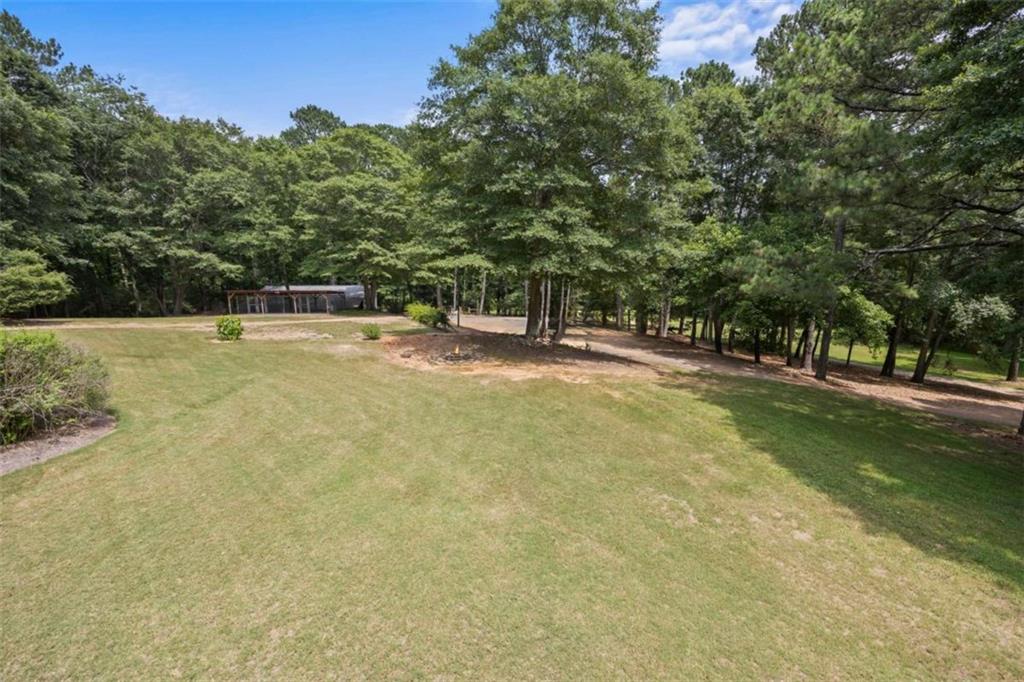 3651 Chandler Haulk Road Loganville, GA 30052 - Photo 10 of 33 a view of yard with swimming pool and trees in the background