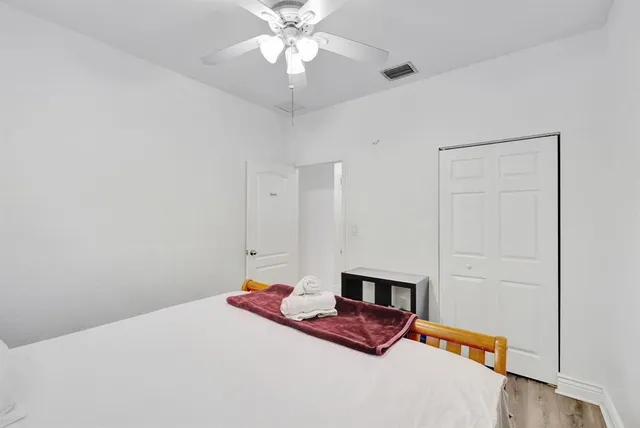 a bedroom with a bed and a chandelier fan