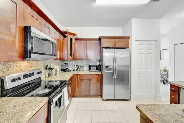 a kitchen with stainless steel appliances granite countertop a refrigerator stove and sink