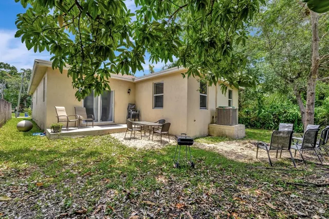 a backyard of a house with table and chairs