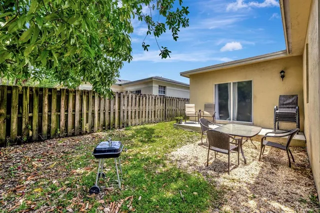 a backyard of a house with table and chairs