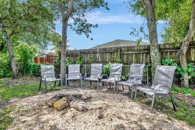 a view of a chairs and table in backyard of the house