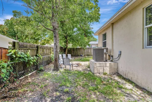 a view of a chair and table in backyard of the house