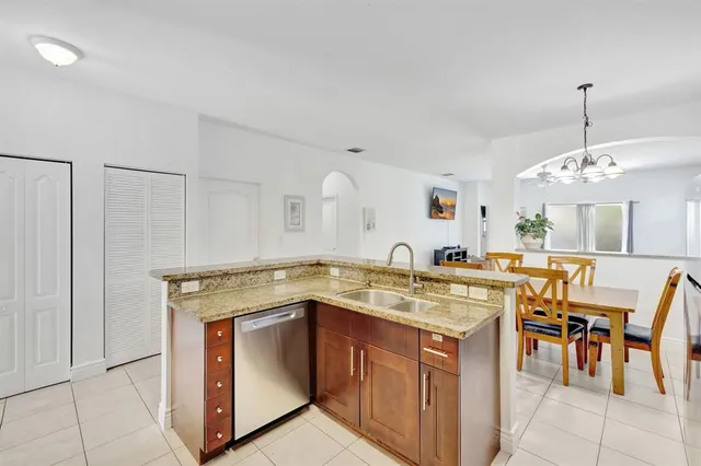 a kitchen with a stove a sink a dining table and chairs
