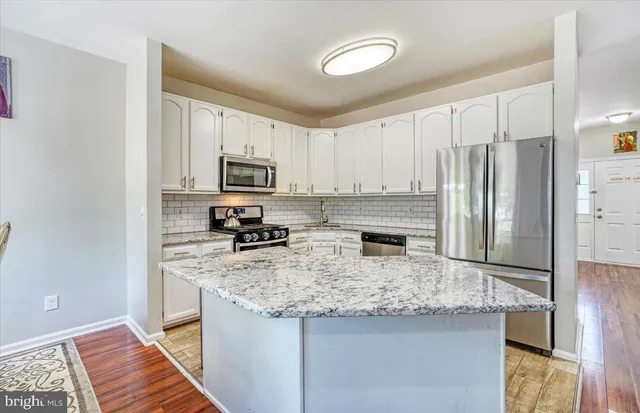 a kitchen with stainless steel appliances granite countertop a refrigerator stove microwave and sink