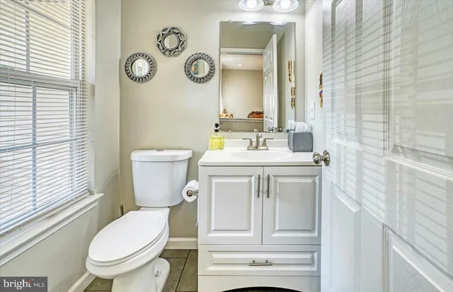 a bathroom with a toilet sink vanity and mirror