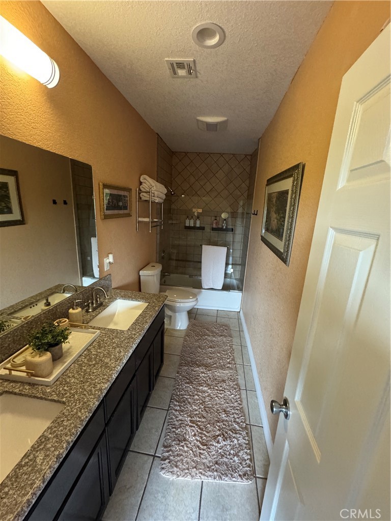 27914 West Shore Road Lake Arrowhead, CA 92352 - Photo 13 of 22 a large bathroom with a granite countertop sink a toilet a mirror and vanity