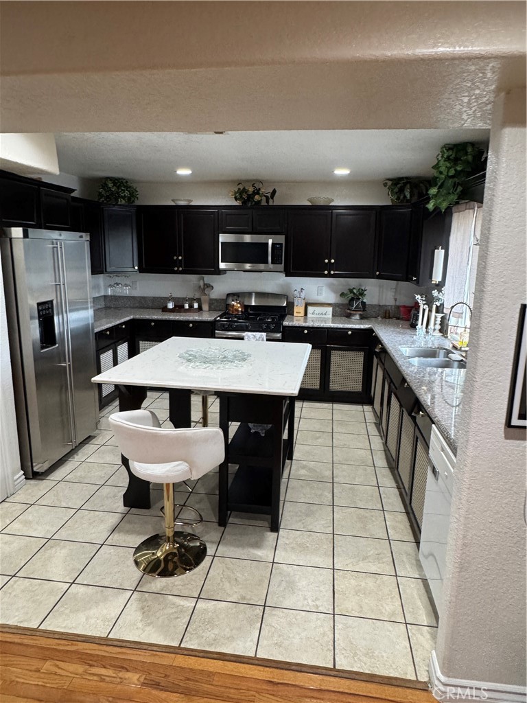 27914 West Shore Road Lake Arrowhead, CA 92352 - Photo 6 of 22 a large kitchen with a large counter top space a sink a stove and stainless steel appliances