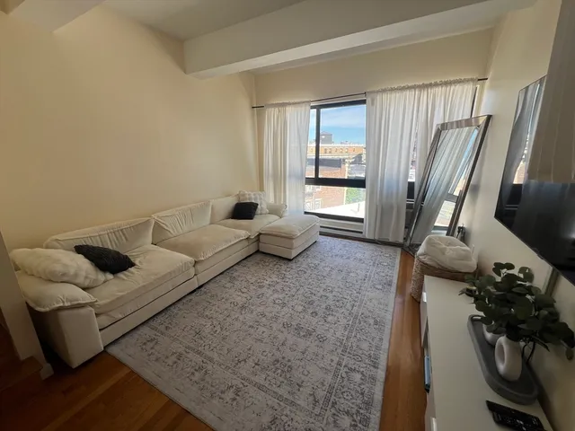 a living room with furniture and a floor to ceiling window