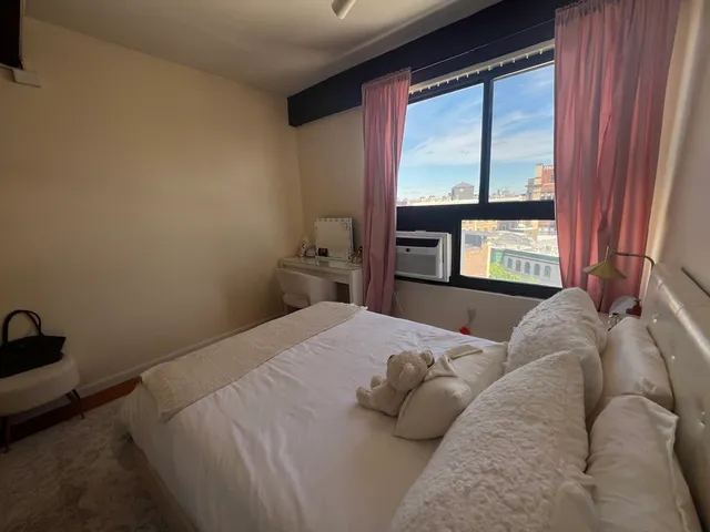 a bed sitting in a bedroom next to a window