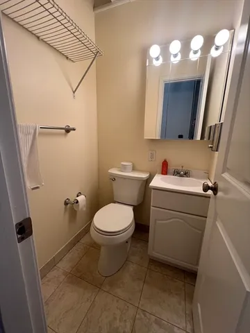 a bathroom with a toilet sink vanity and mirror