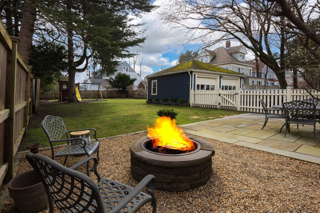 75 Clinton Place Newton, MA 02459 - Photo 17 of 18 a view of a backyard with table and chairs and a fire pit