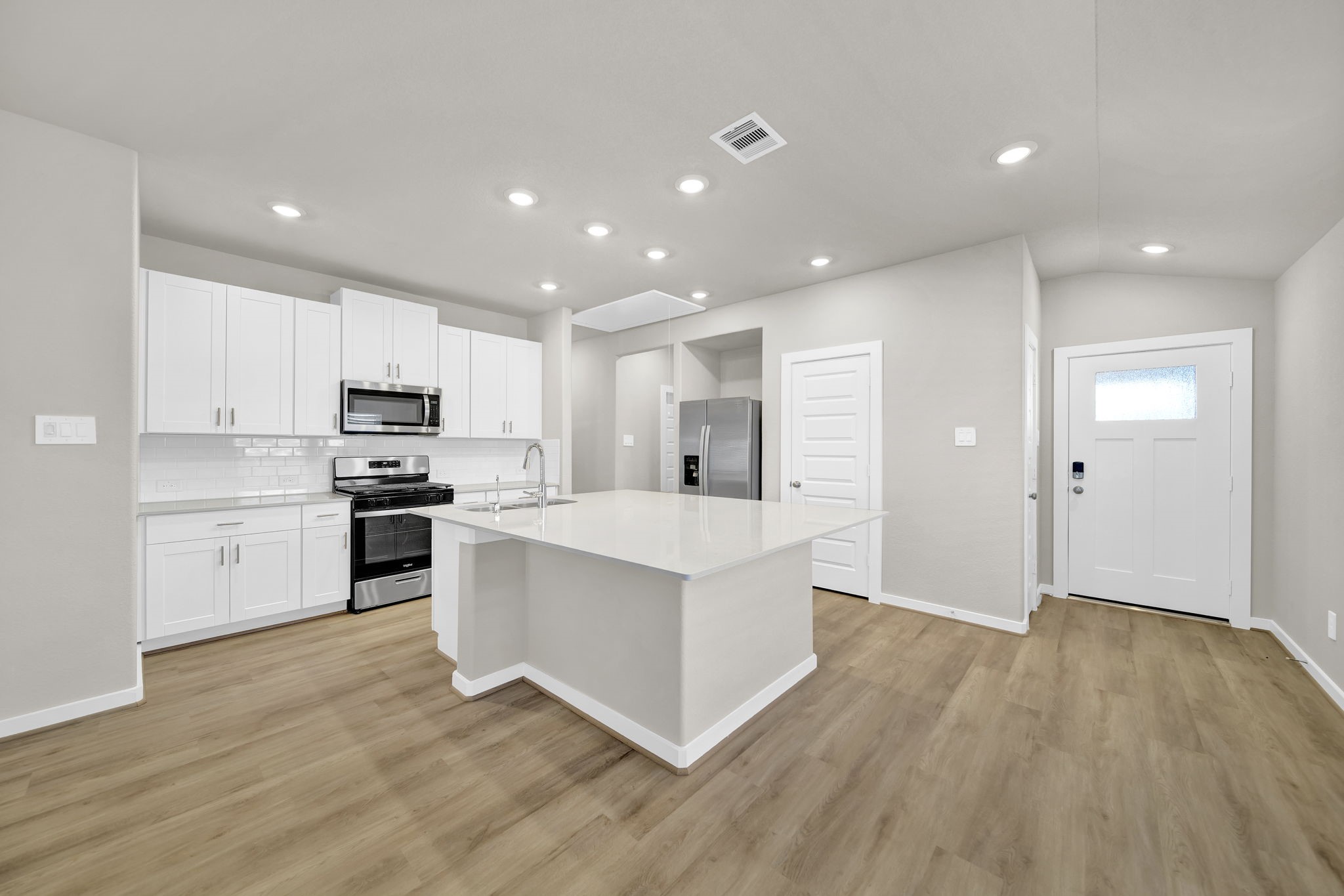 16675 Sterling Clf Street Conroe, TX 77302 - Photo 4 of 21 a kitchen with white cabinets and stainless steel appliances
