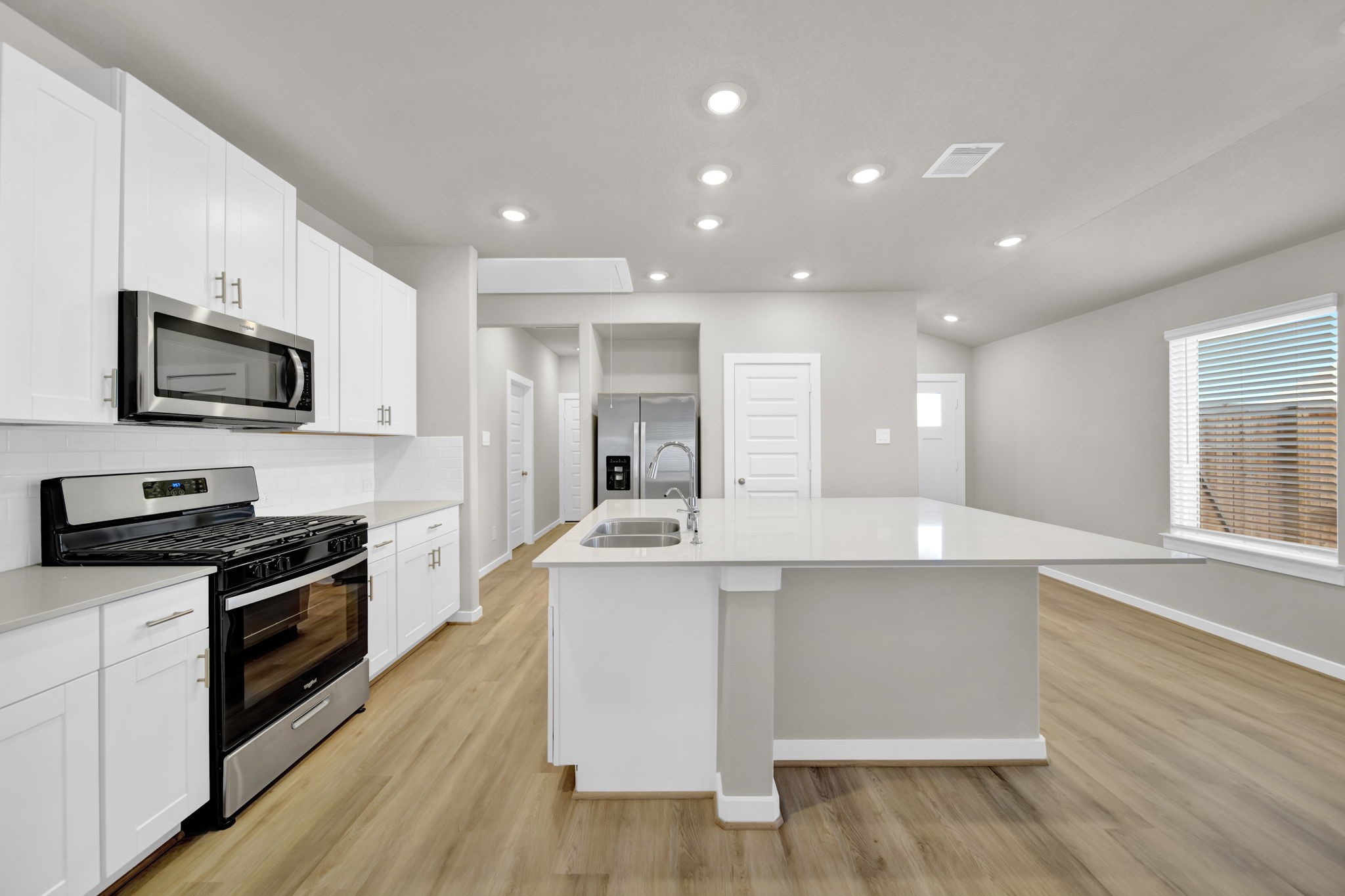 16675 Sterling Clf Street Conroe, TX 77302 - Photo 5 of 21 a large kitchen with stainless steel appliances a large counter top a stove a sink and a refrigerator