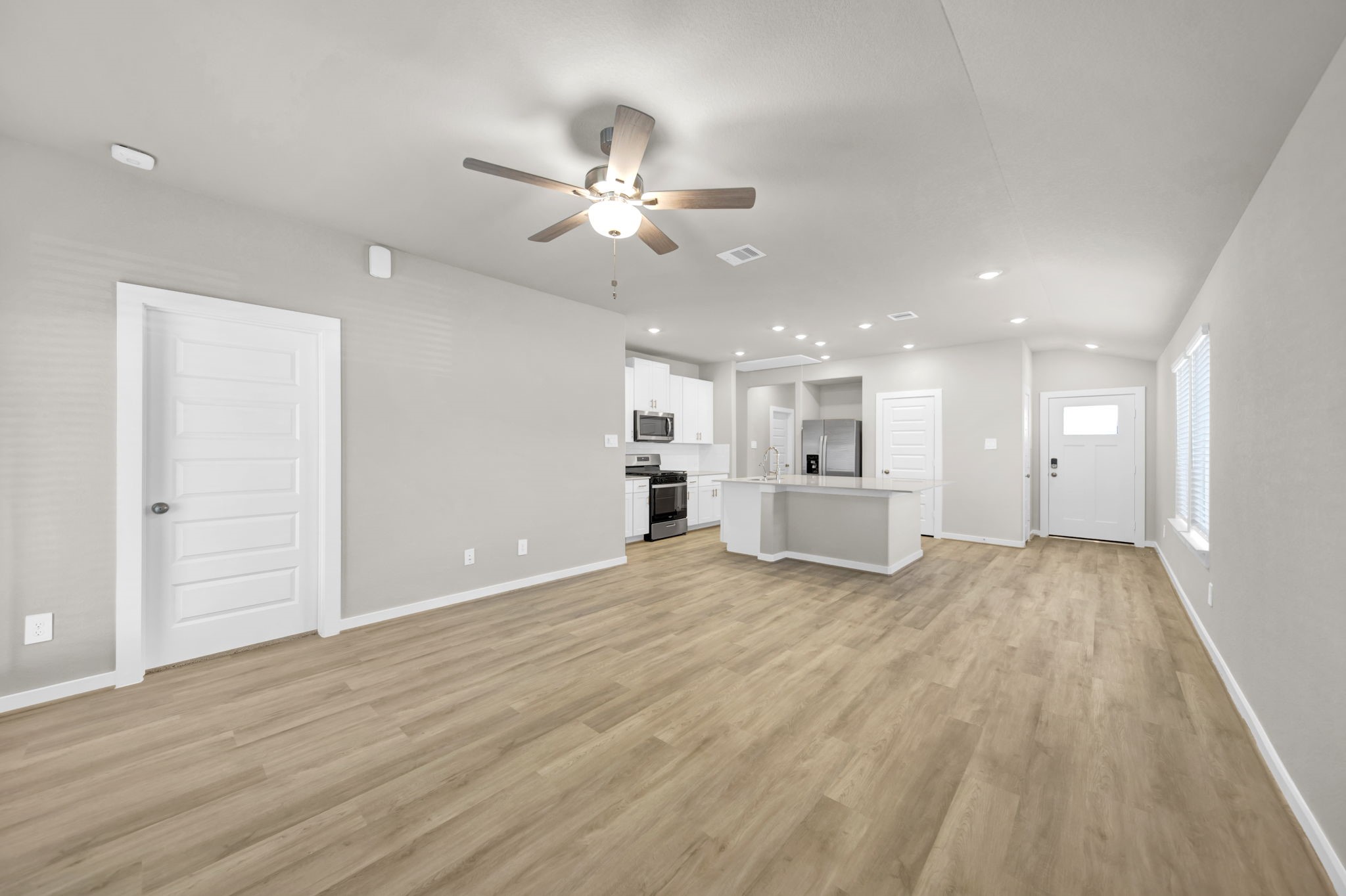 16675 Sterling Clf Street Conroe, TX 77302 - Photo 8 of 21 a view of an empty room with wooden floor and a ceiling fan