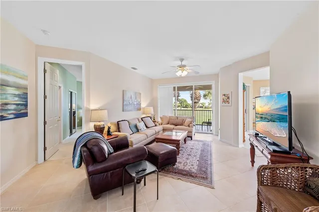 a living room with furniture a flat screen tv and a large window