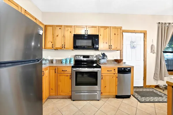 a kitchen with stainless steel appliances granite countertop a stove a sink and a refrigerator