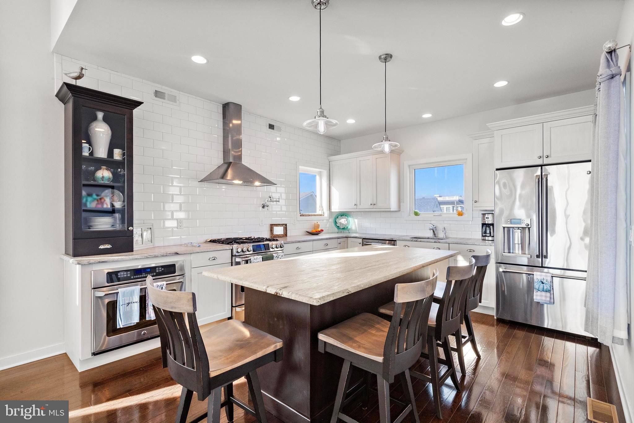 27 West 33rd Street Long Beach Township, NJ 08008 - Photo 30 of 83 a kitchen with a dining table chairs appliances and cabinets