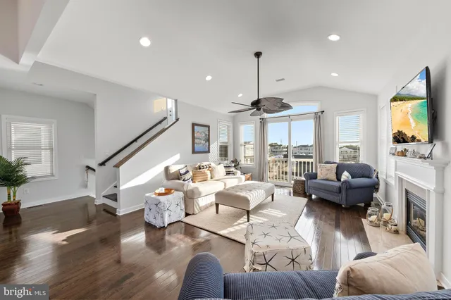 an aerial view of a house with lots of residential buildings ocean and mountain view in back