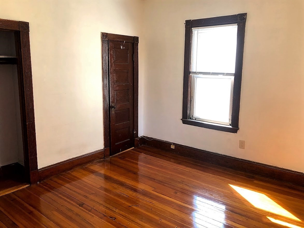 28 Litchfield Street, Unit 3 Boston, MA 02135 - Photo 9 of 11 an empty room with wooden floor and windows