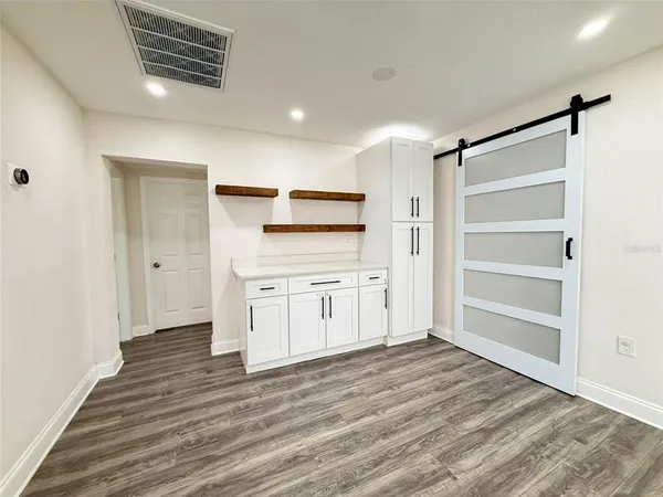 a view of a kitchen with wooden floor and a refrigerator