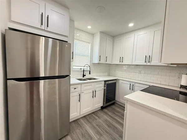 a kitchen with stainless steel appliances a refrigerator sink and cabinets