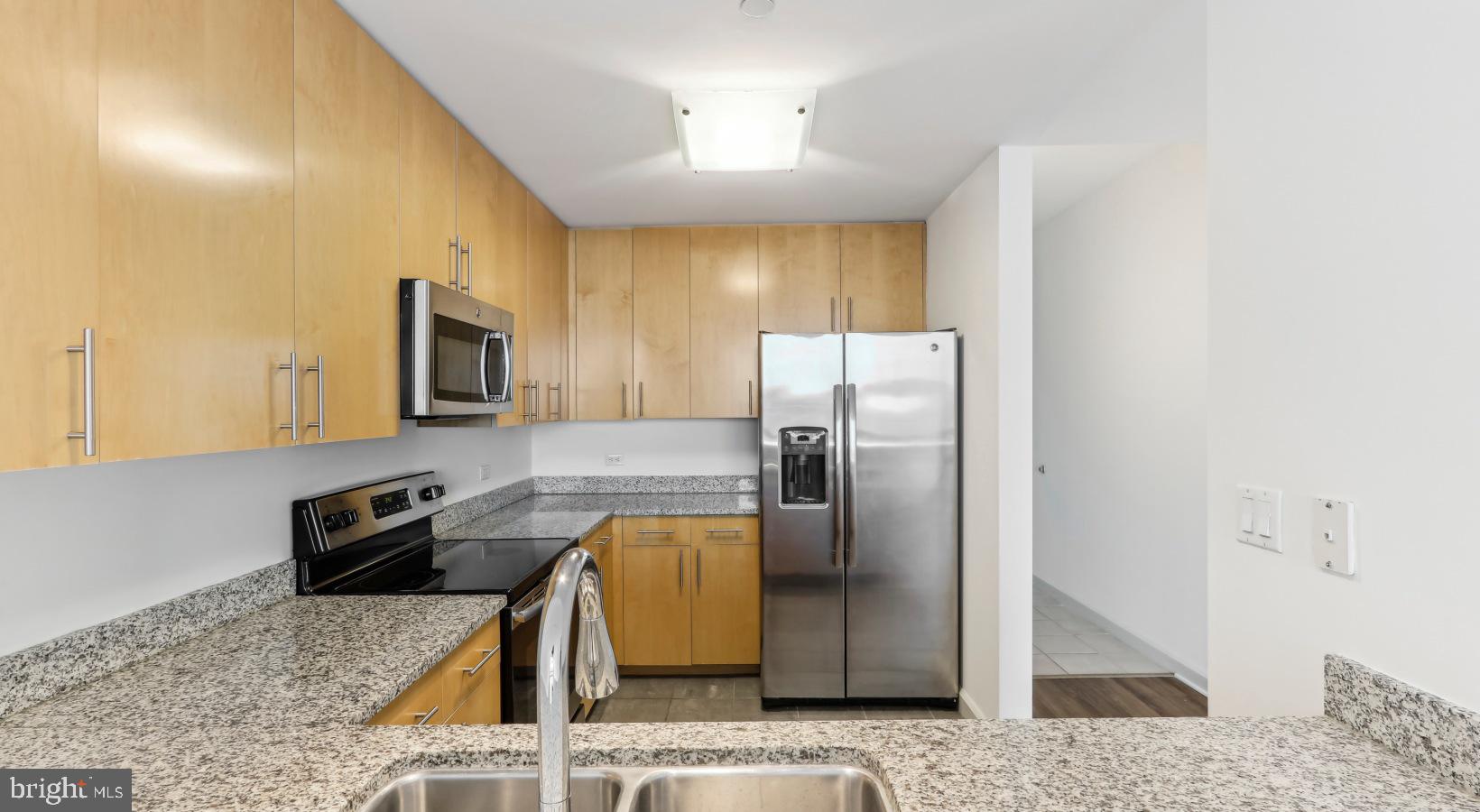 206 West Washington Square, Unit 1908 Philadelphia, PA 19106 - Photo 14 of 31 a kitchen with stainless steel appliances granite countertop a refrigerator a stove and a sink