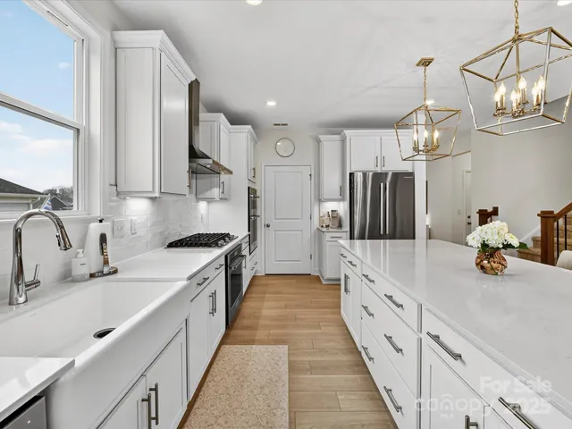 a large kitchen with stainless steel appliances lots of counter space and wooden floor