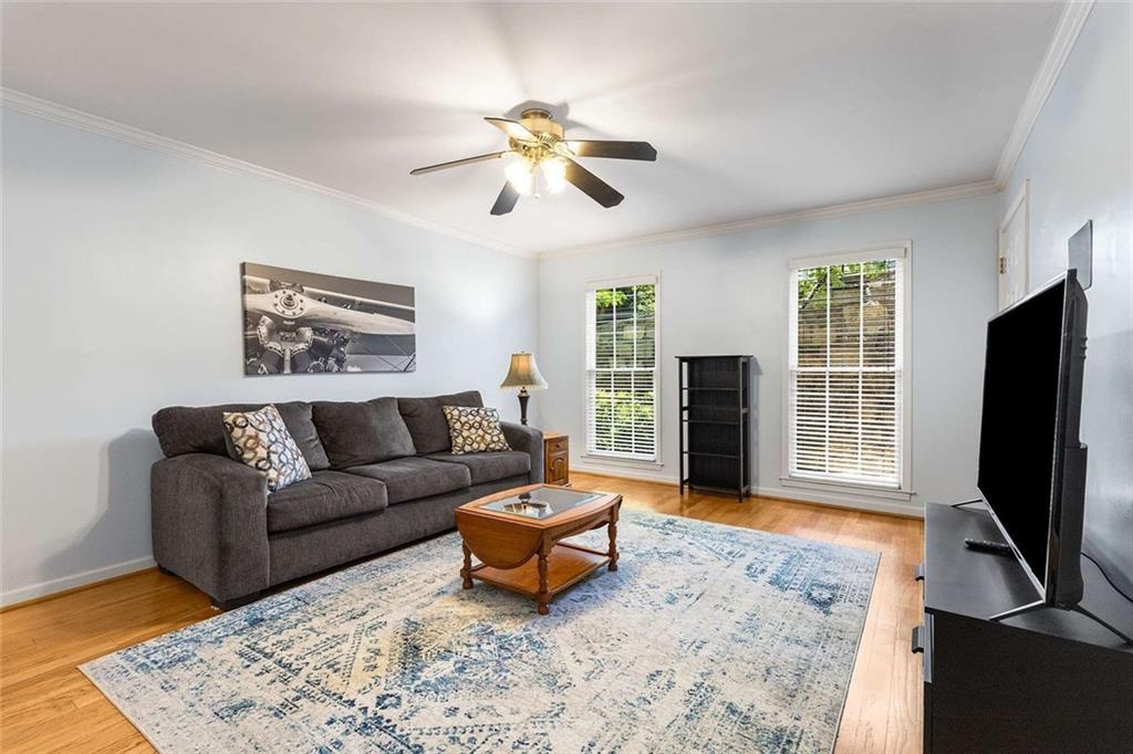 a living room with furniture a flat screen tv and a window