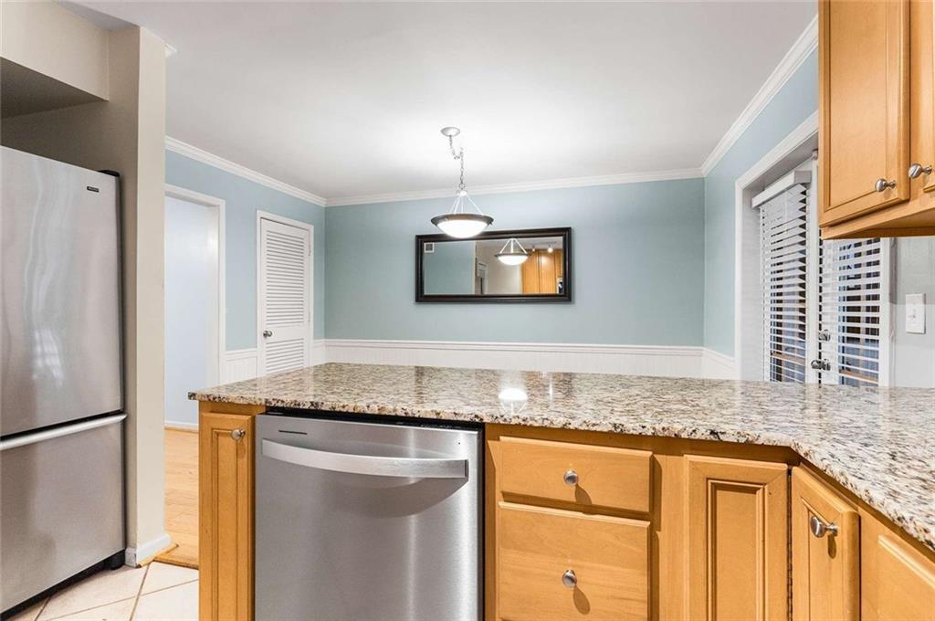 1101 Collier Road Northwest, Unit P2 Atlanta, GA 30318 - Photo 11 of 26 a kitchen with granite countertop cabinets stainless steel appliances and a counter space