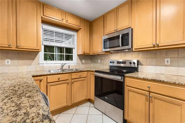 a kitchen with stainless steel appliances granite countertop a sink stove and microwave
